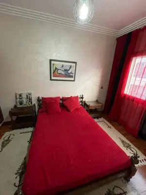 a large red bed with red pillows in a bedroom at residence rania in Maarif