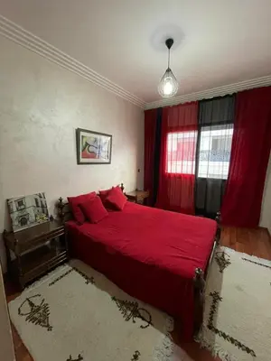 a bedroom with a red bed and red curtains at residence rania in Maarif