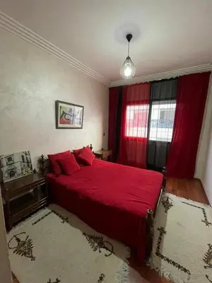 a bedroom with a red bed and a window at residence rania in Maarif