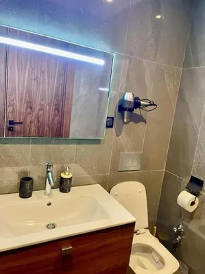 a bathroom with a sink and a toilet and a mirror at Vue imprenable sur Casa Finance City in Casablanca