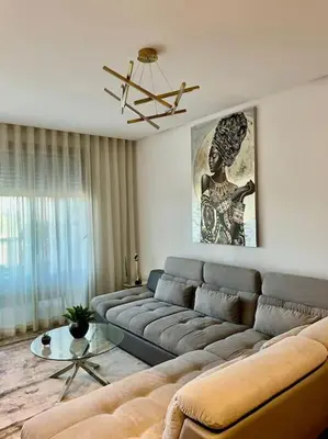 a living room with a large couch and a table at Vue imprenable sur Casa Finance City in Casablanca
