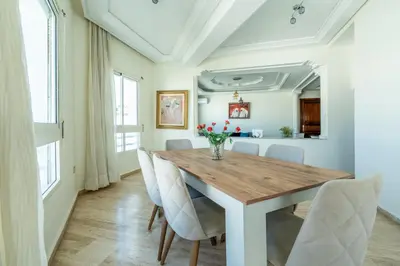 a dining room with a wooden table and chairs at Appartement à Maarif, Proche du Twin et McDonald's in Casablanca