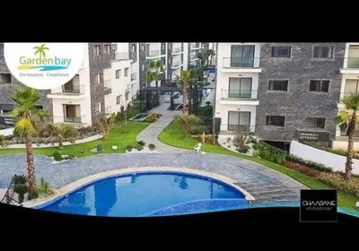a large swimming pool in front of a building at Superbe Appartement pieds dans l'eau - Résidence GARDENBAY in Dar Mohammed Ould Haj Jilali
