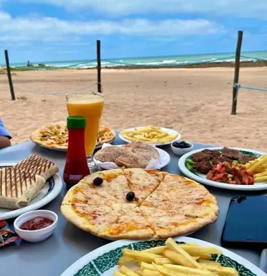a table with plates of food on a beach at Superbe Appartement pieds dans l'eau - Résidence GARDENBAY in Dar Mohammed Ould Haj Jilali