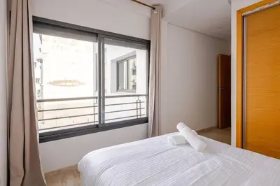 a bedroom with a white bed and a large window at Casa Gauthier - TT Holidays in Casablanca