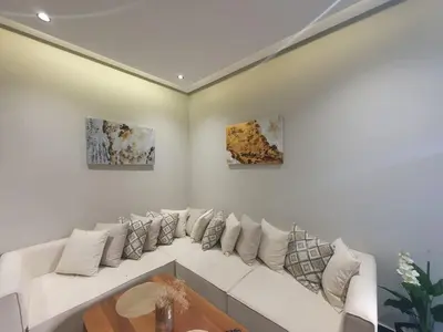 a white living room with a white couch with pillows at Studio élégant in Casablanca