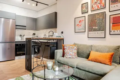 a living room with a couch and a kitchen at Emerald 32 Bourgogne Studio in Casablanca