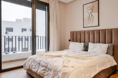 a bedroom with a large bed and a large window at Emerald 32 Bourgogne Studio in Casablanca
