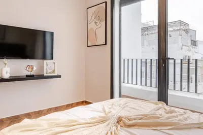 a bedroom with a bed and a tv and a window at Emerald 32 Bourgogne Studio in Casablanca