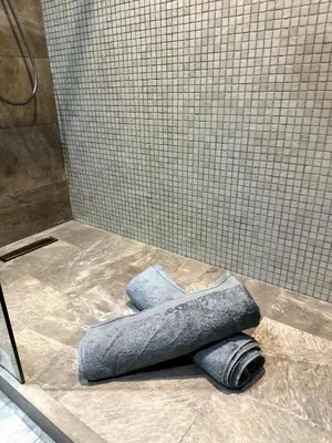 a shower with two rolled up towels on the floor at Skyline Albert Luxury 2 a proximité de la gare Casa voyageurs Casablanca in Casablanca