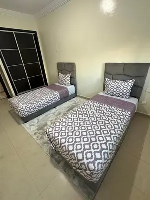 two beds sitting in a room with at Appartement corniche d'or, Mohammedia in Mohammedia