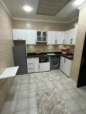 a kitchen with white cabinets and a washer and dryer at Appartement corniche d'or, Mohammedia in Mohammedia