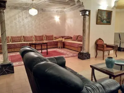 a living room with a leather couch and a table at Spacious apartment in Rabat Agdal 1937,5 ft2 - 180m2 in Rabat
