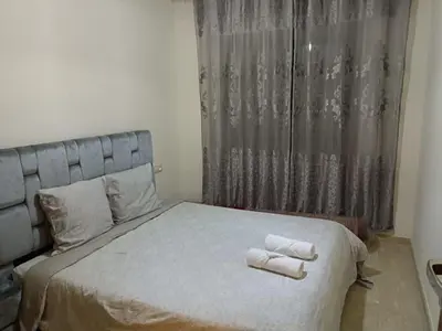 a bedroom with a bed with two towels on it at Appartement spacieux 3 chambres avec parking privé in Nouaceur