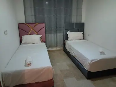 two beds sitting next to each other in a room at Appartement spacieux 3 chambres avec parking privé in Nouaceur