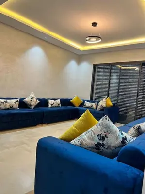 a living room with blue couches and yellow pillows at Appartement - EL Mansouria - Mohammadia - Bouznika in Mansouria