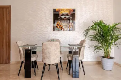 a dining room with a table with chairs and a painting at Loft Moderne Cosy avec Terrasse vue unique centre de Casablanca in Casablanca