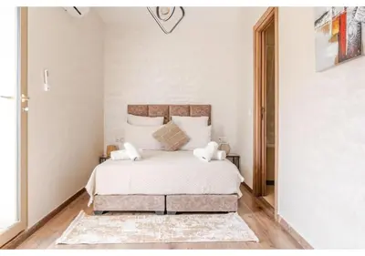 a bedroom with a bed with white sheets and pillows at Loft Moderne Cosy avec Terrasse vue unique centre de Casablanca in Casablanca