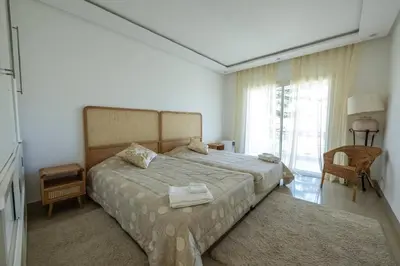 a bedroom with a bed and a large window at Ocean Pearl - Exclusive 2BR Oceanfront Luxury & Views in Bouznika