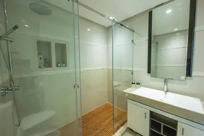 a bathroom with a shower and a sink and a mirror at Ocean Pearl - Exclusive 2BR Oceanfront Luxury & Views in Bouznika
