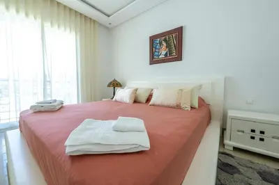a bedroom with a large bed with towels on it at Ocean Pearl - Exclusive 2BR Oceanfront Luxury & Views in Bouznika