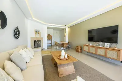 a living room with a white couch and a tv at Ocean Pearl - Exclusive 2BR Oceanfront Luxury & Views in Bouznika