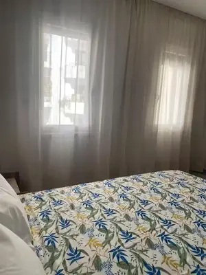 a bed with a blanket with blue flowers on it at Studio l'Escale D'Agdal in Rabat