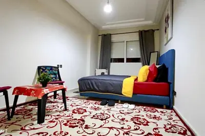 a bedroom with a bed and a chair and a rug at Turner Vision in Casablanca