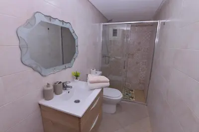a bathroom with a toilet and a sink and a mirror at Cozy Duplex appartement wifi parking proximité in Rabat