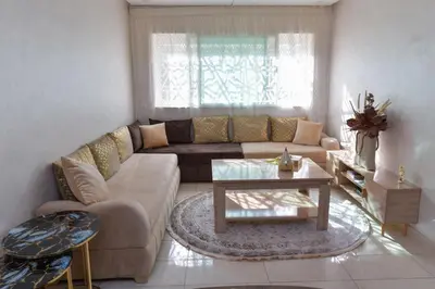 a living room with a couch and a table at Cozy Duplex appartement wifi parking proximité in Rabat