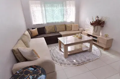 a living room with a couch and a table at Cozy Duplex appartement wifi parking proximité in Rabat