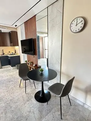 a room with a table and two chairs and a clock at Studio Monaco in Casablanca
