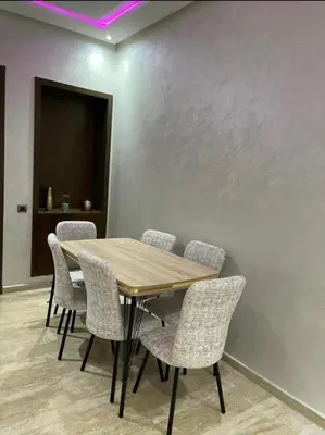 a dining room with a wooden table and chairs at les crêtes dar bouazza in Tamaris