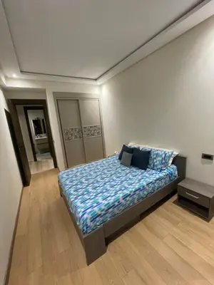 a bedroom with a bed with a blue comforter at les crêtes dar bouazza in Tamaris
