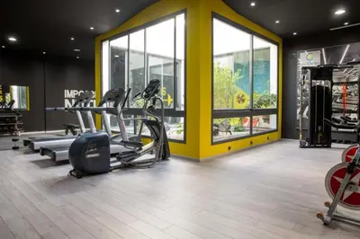 a gym with treadmills and elliptical machines and windows at les crêtes dar bouazza in Tamaris