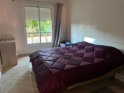a bedroom with a purple bed with a window at Apartment in O Ben Slimane