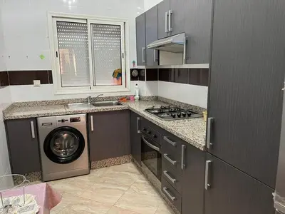 a kitchen with a washer and a washing machine at Apartment in O Ben Slimane