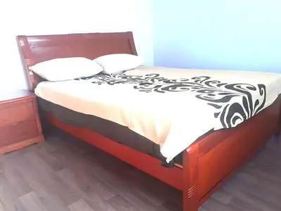 a bed with a black and white comforter and a night stand at Lux Appartement maarif in Casablanca