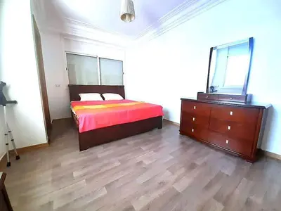 a bedroom with a bed and a dresser and a mirror at Lux Appartement maarif in Casablanca