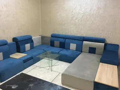 a room with a blue couch and a glass table at larc in Deroua