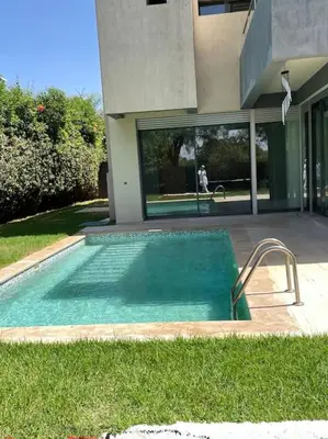 a small swimming pool in front of a house at Luxurious Golf Villa with Pool in Bouskoura