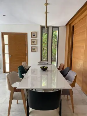 a dining room with a white table and chairs at Luxurious Golf Villa with Pool in Bouskoura
