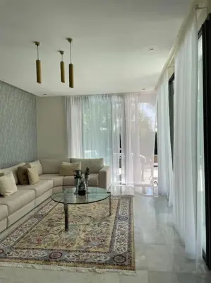 a living room with a couch and a table at Luxurious Golf Villa with Pool in Bouskoura