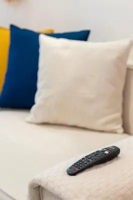 a remote control sitting on a bed with pillows at Prestigia Luxe Suite by MERAT HOME in Rabat