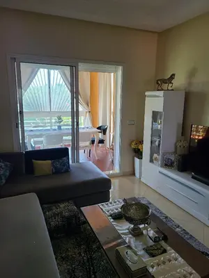 a living room with a couch and a table at Ricoflores palm benslimane in O Ben Slimane