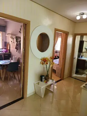 a living room with a table and a mirror at Ricoflores palm benslimane in O Ben Slimane