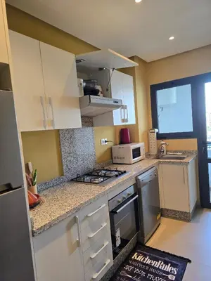 a kitchen with white cabinets and a stove top oven at Charmant appartement à 10min de L' Aéroport Med V in Nouaceur
