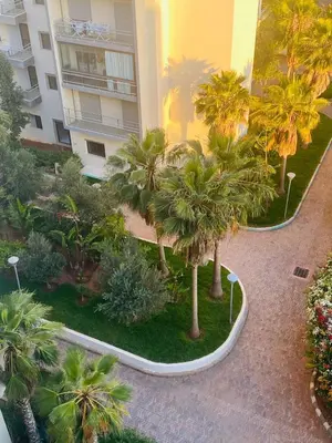 an aerial view of a courtyard with palm trees and a building at Charmant appartement à 10min de L' Aéroport Med V in Nouaceur