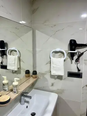 a white bathroom with a sink and a mirror at Sea view apartment in Casablanca