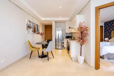 a kitchen and living room with a bed and a table and chairs at Emplacement Chic Lumineux & Central Près du Consulat Américain 2 minutes de Twin Center Gauthier Casablanca in Casablanca